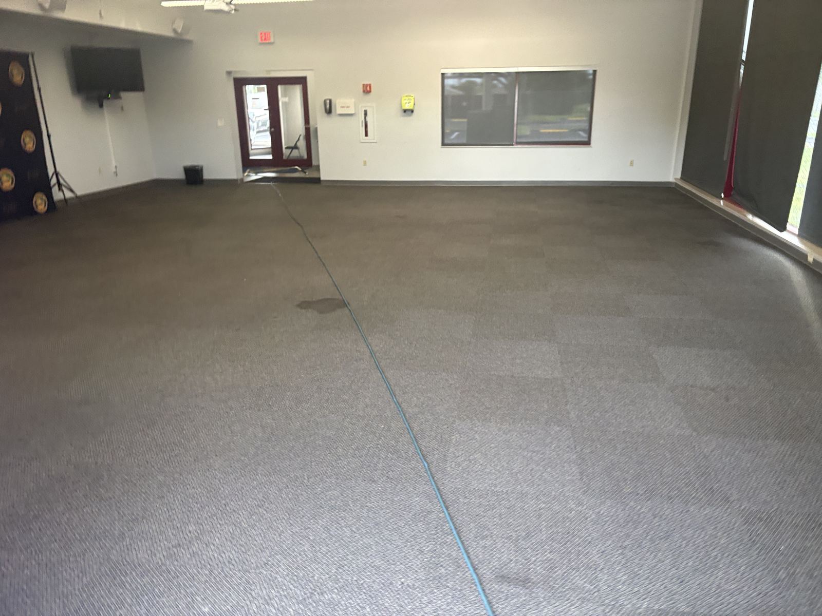 Gray carpet in a large open room, before cleaning