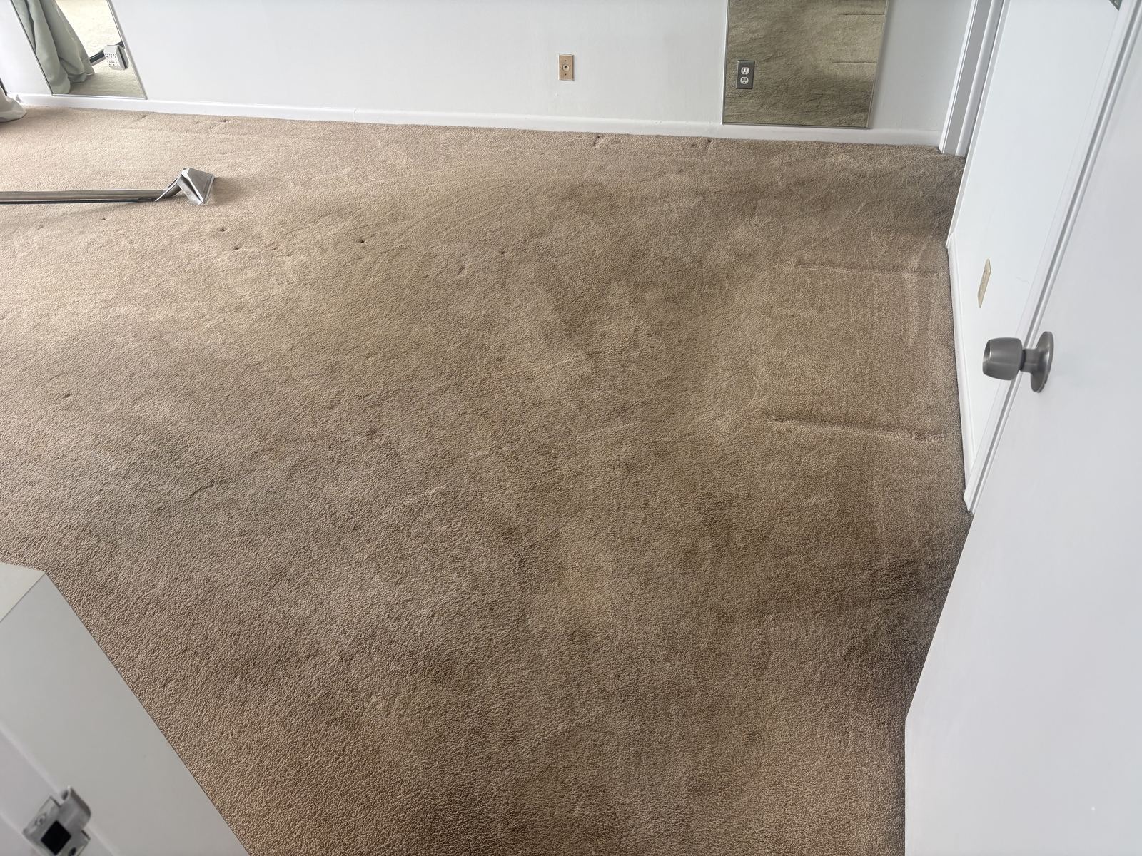 Tan carpet in an empty room, before cleaning
