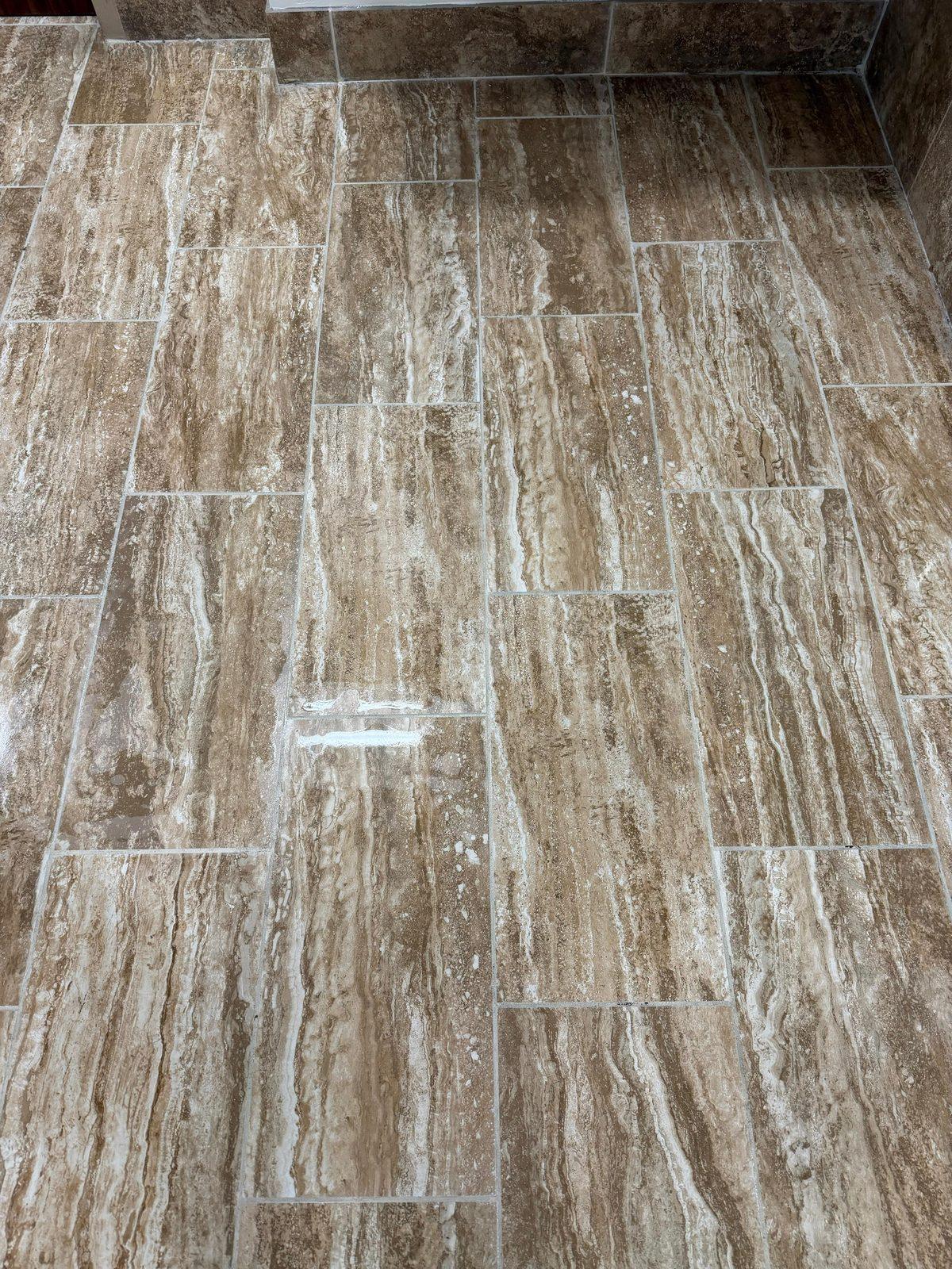 Floor tiles and grout lines with a light mark on one tile