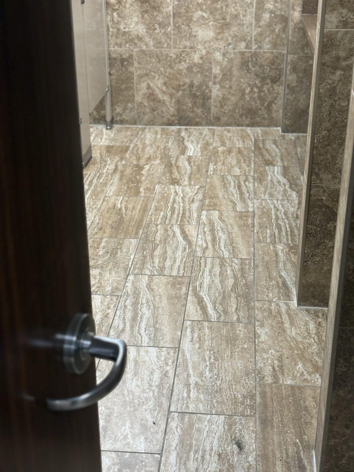 Tile floor in a restroom, seen through the open door